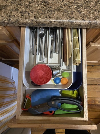slim kitchen drawer with large utensil organizer and jumble of kitchen tools