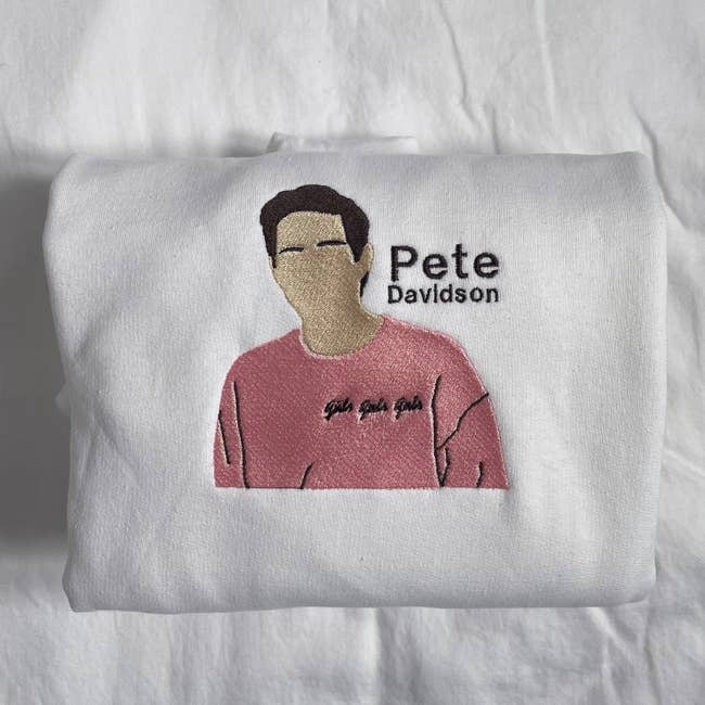 a white sweatshirt with pete davidson's face embroidered on it
