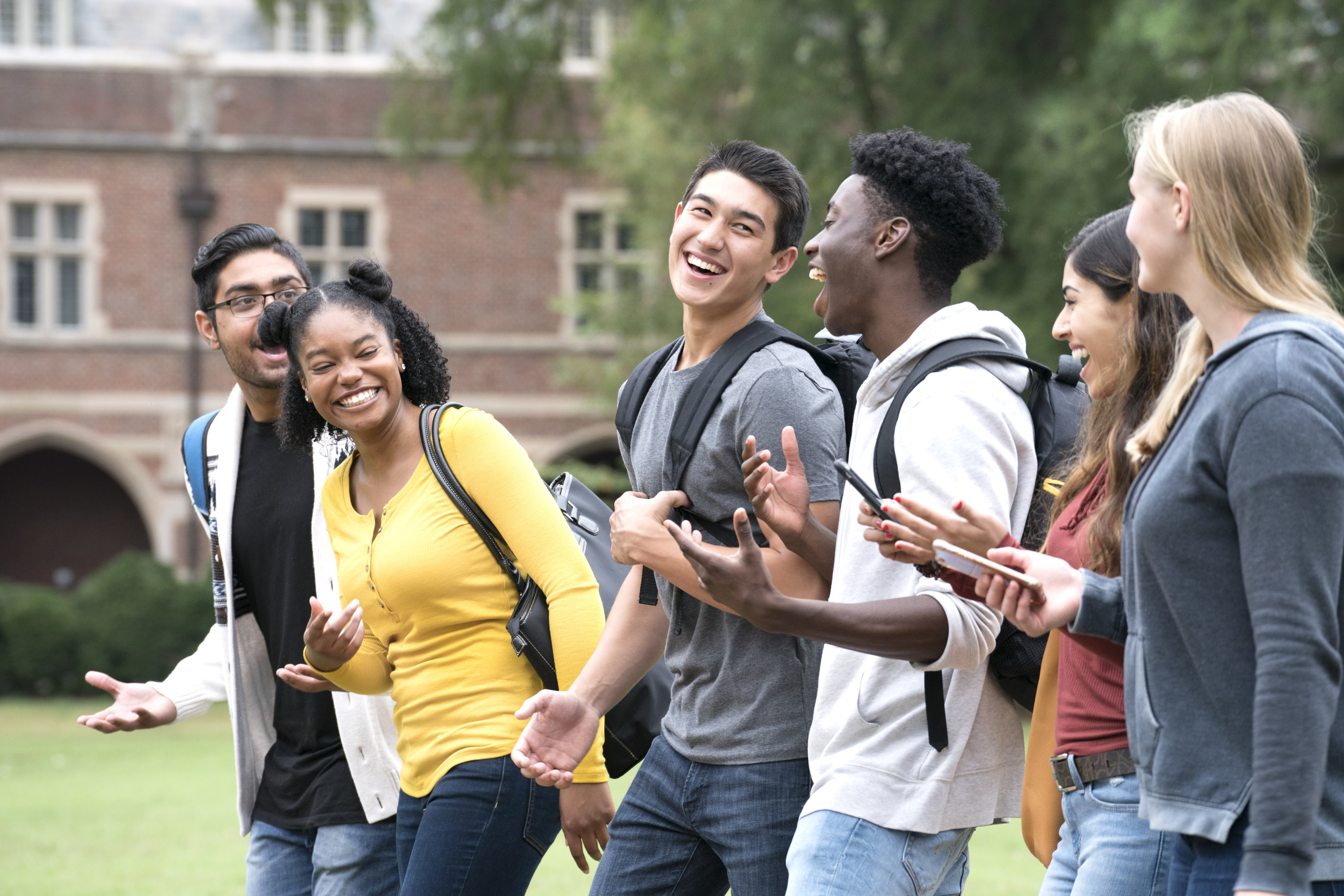 happy students walking outside of school