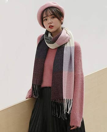 A model wearing the plaid scarf with pink and purple tones.