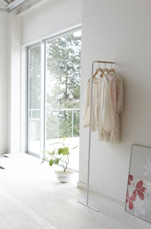 a bare room with a clothing rack