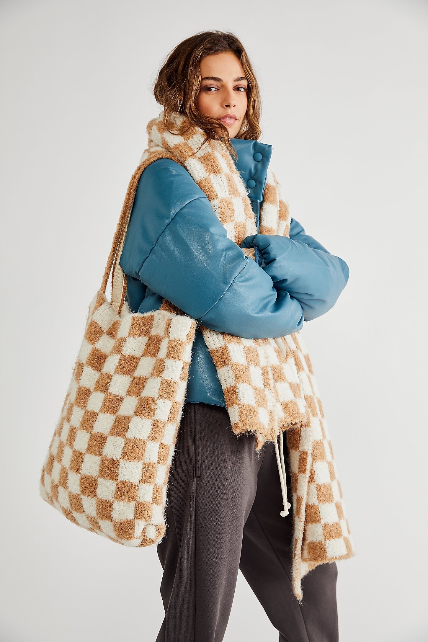 a model wears both the scarf and bag in the camel and ivory checkered print