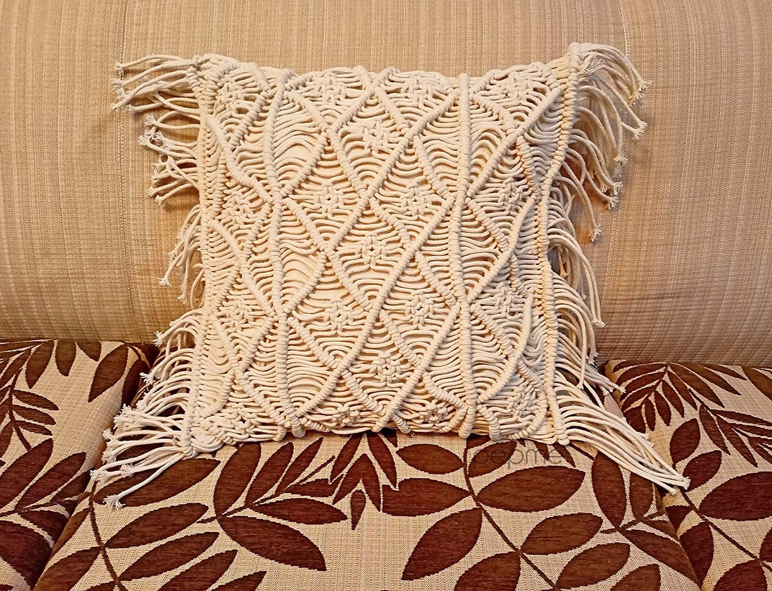 A sofa with a Macrame pillow on it