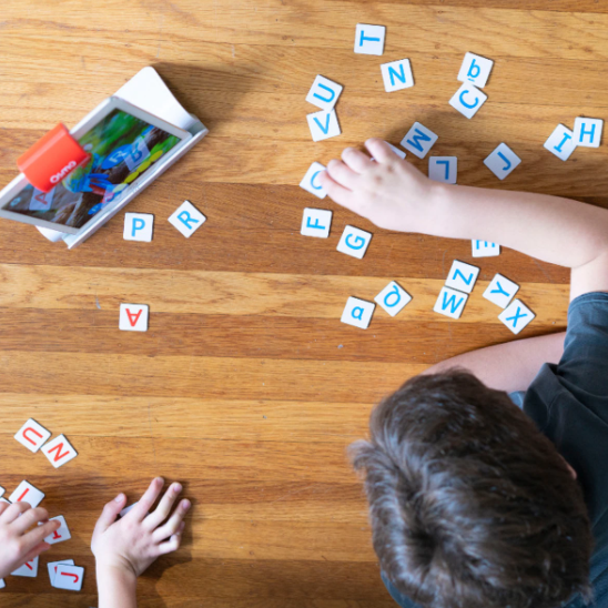 Kids playing with letter tiles 