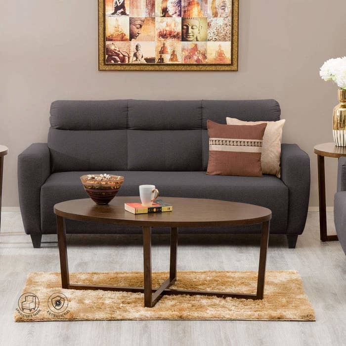A brown sofa in a living room with a table in front of it