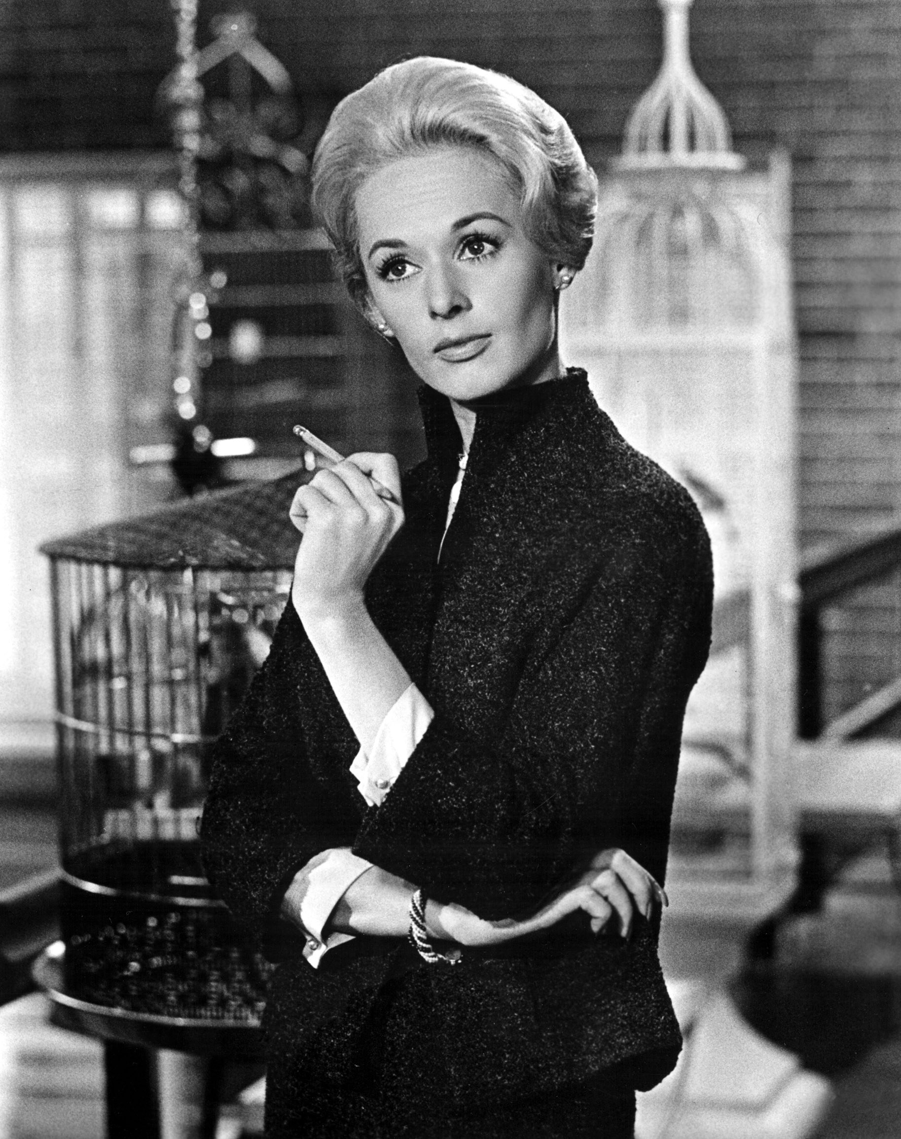 Hedren holds a cigarette while crossing her arms
