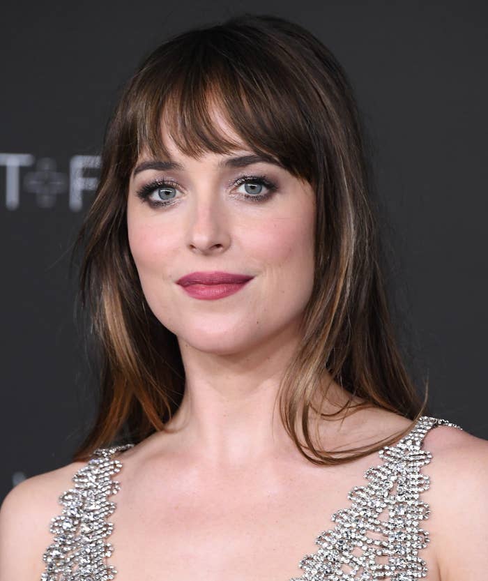 Dakota Johnson looks into the camera at an event