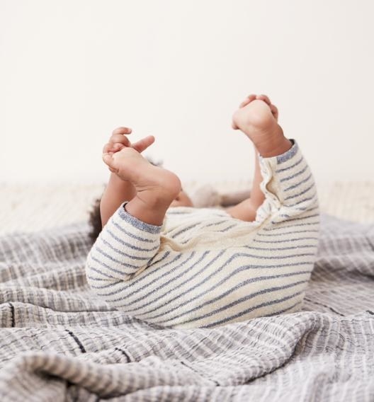 a baby reaching for their feet