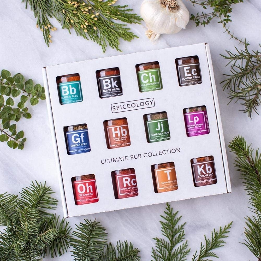 a flatlay of the 12-piece spice set surrounded by fresh evergreen boughs