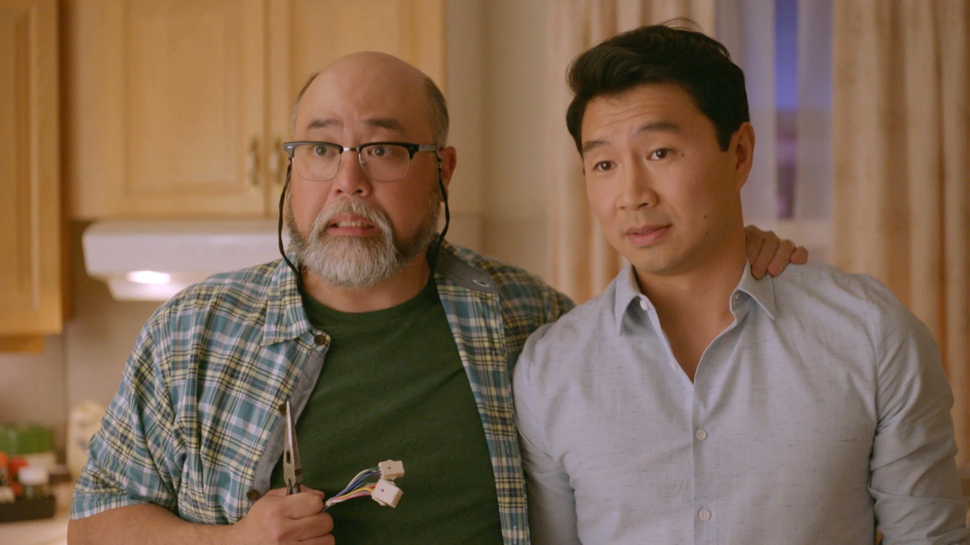 Simu and Paul Sun-Hyung Lee standing in a kitchen in a scene from Kim&#x27;s Convenience
