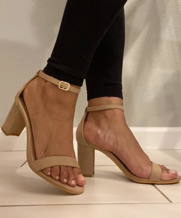 A reviewer wearing a pair of nude suede ankle strap chunky open toe sandal pumps