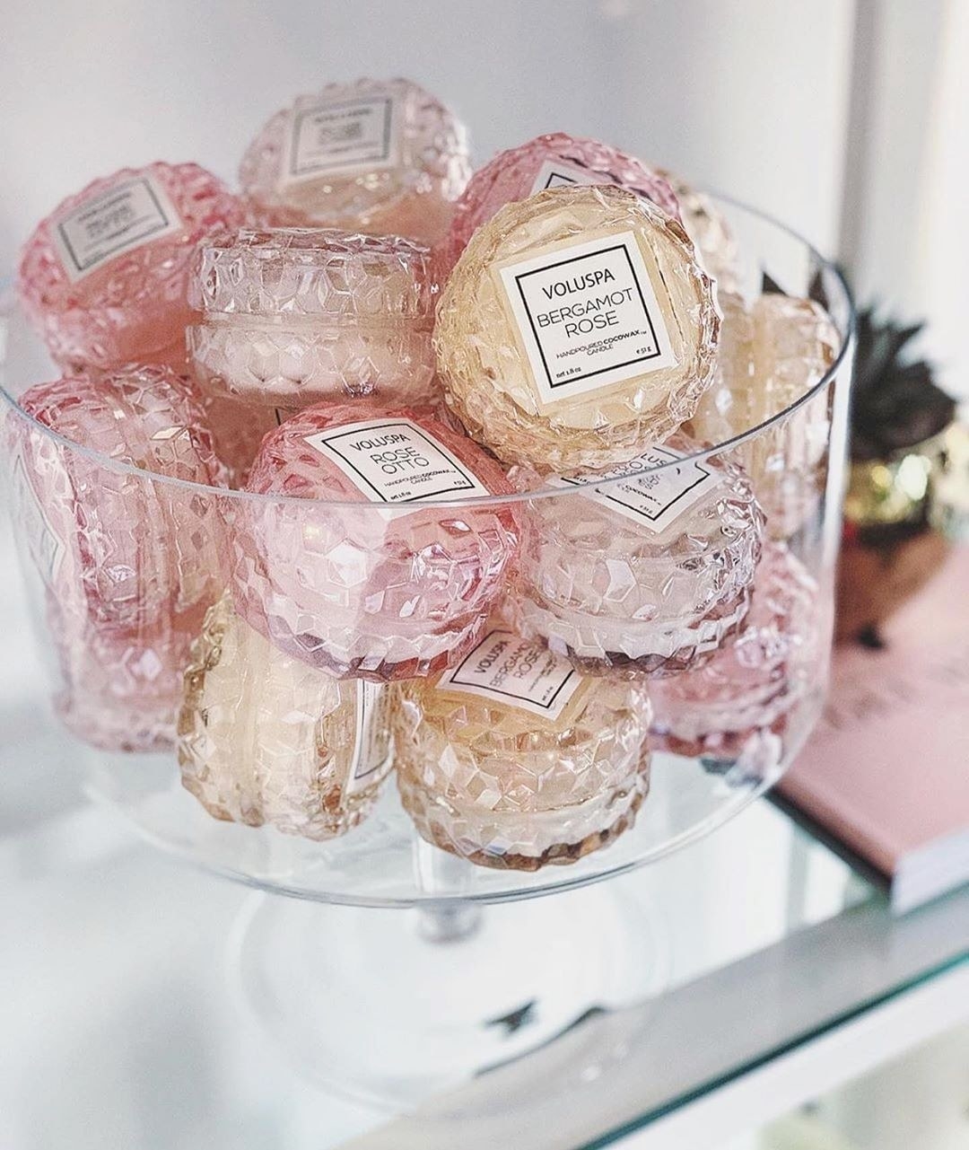 a large glass container filled with macaron-shaped scented candles