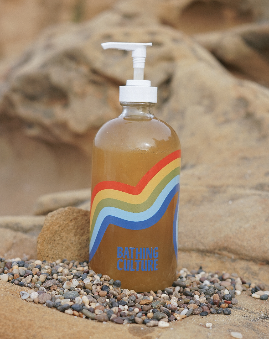 glass bottle of bathing culture body wash in the sand