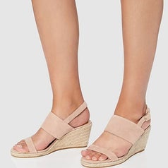 A model wearing the same pair of espadrille wedge sandals in pink suede