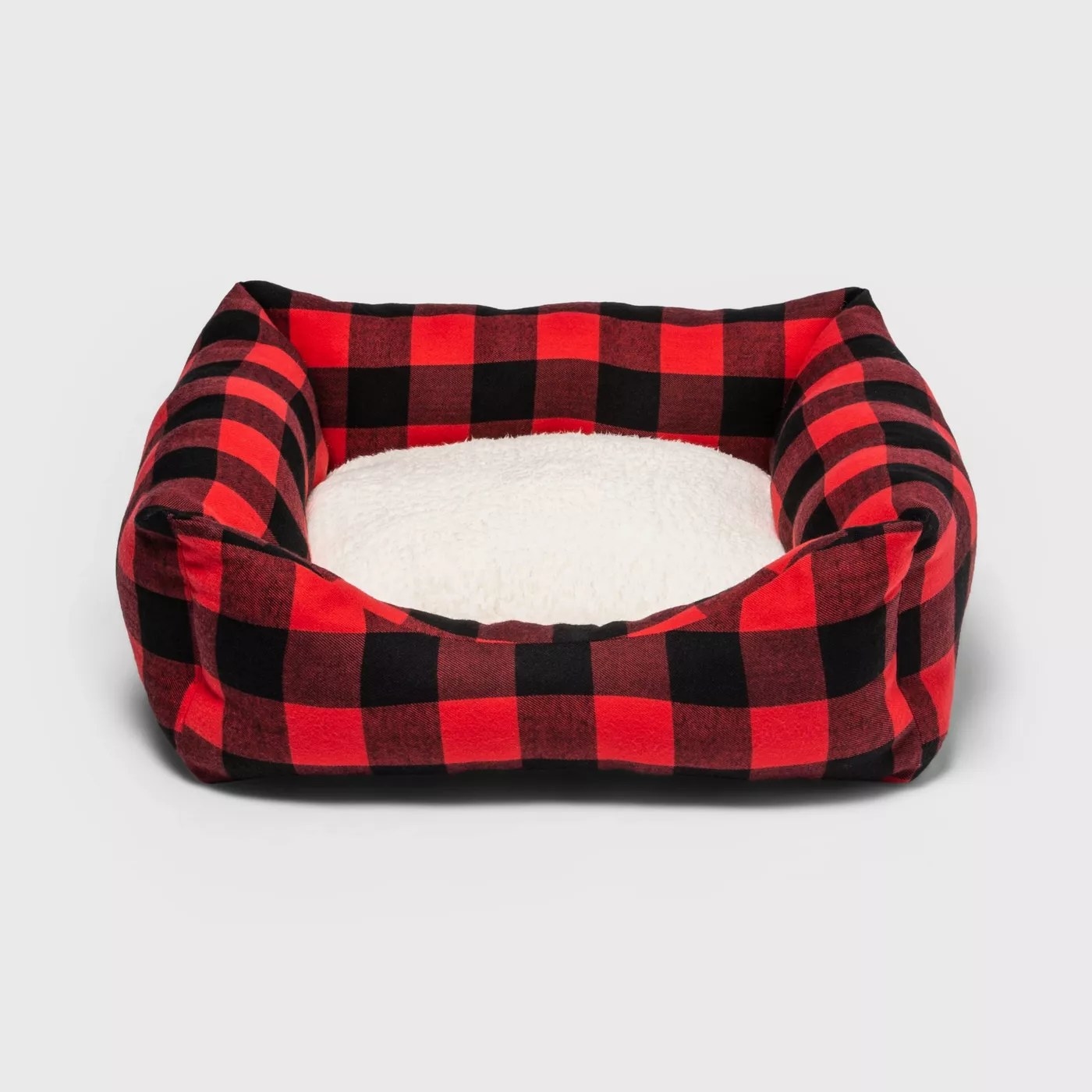 The red and black dog bed with a Sherpa cushion