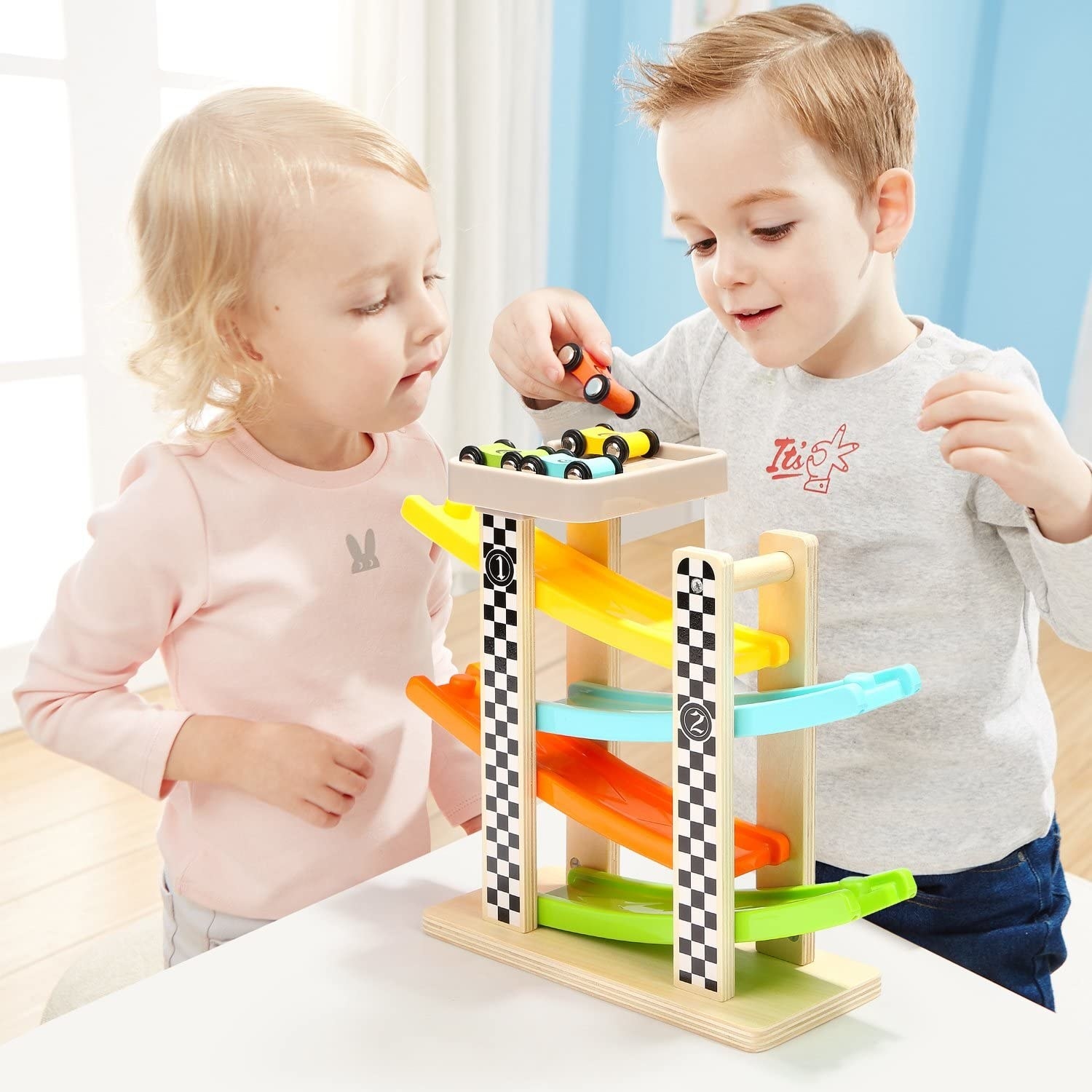 Two kids playing with a wooden race car set