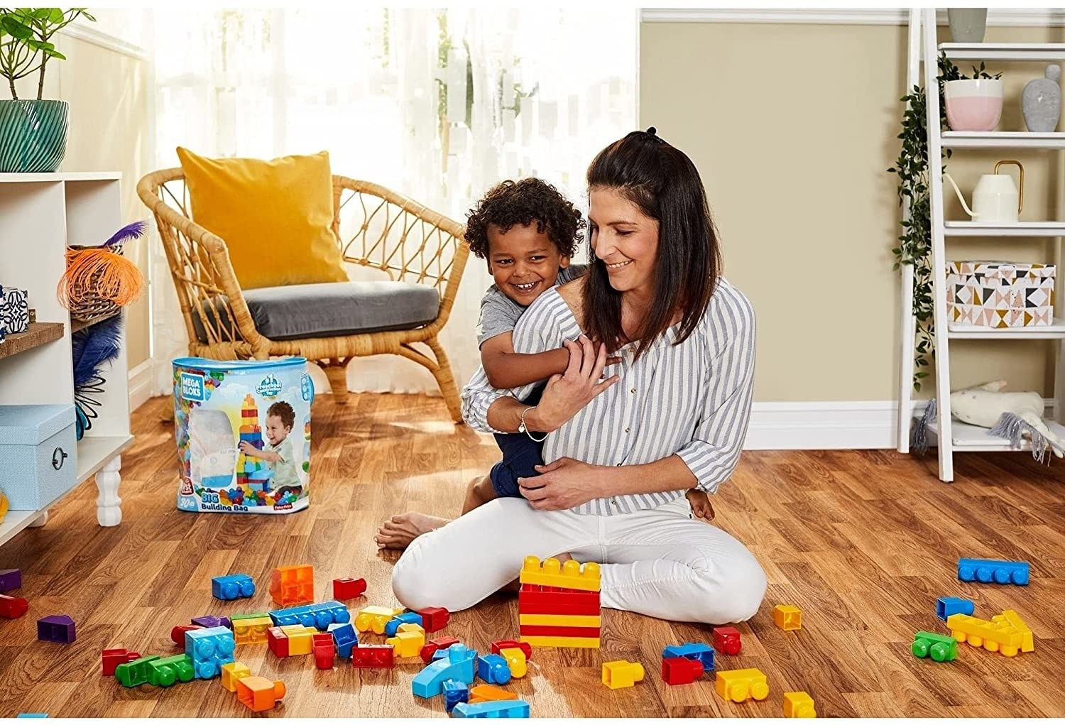 A parent and child playing on the floor with blocks surrounding them