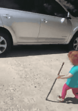 A little kid walks right into a car and falls down