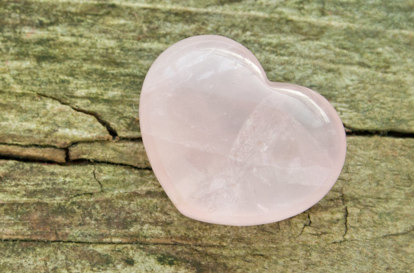 rose quartz heart on wooden ground