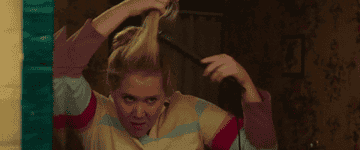 Amy Schumer in &quot;I Feel Pretty&quot; using a flat iron on her hair