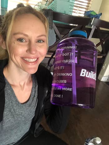reviewer carries purple motivational water bottle in hand