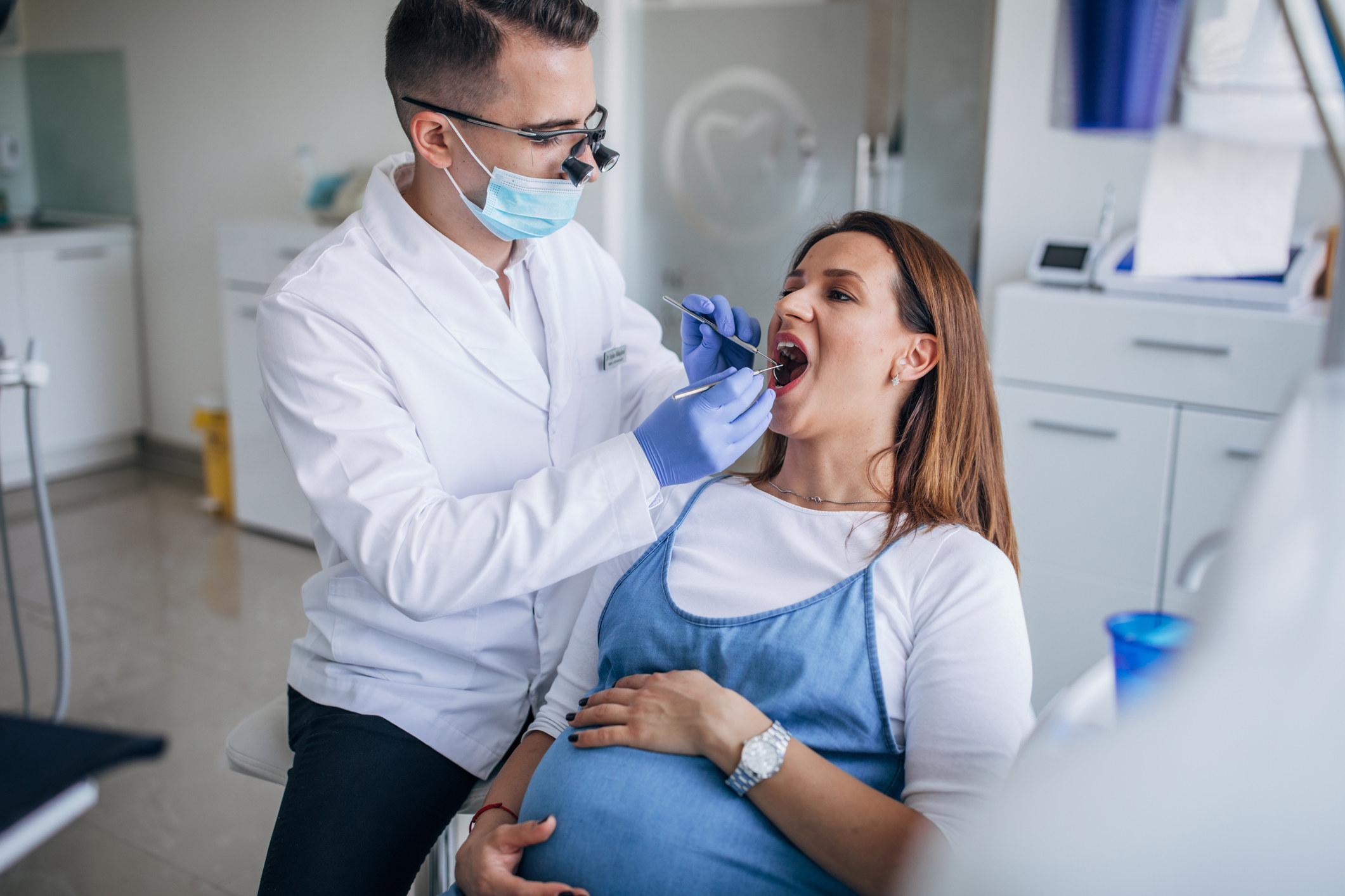 A pregnant woman getting her teeth checked by her dentist