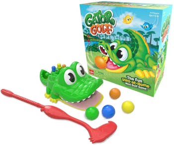 An alligator mouth, a golf club and balls next to packaging