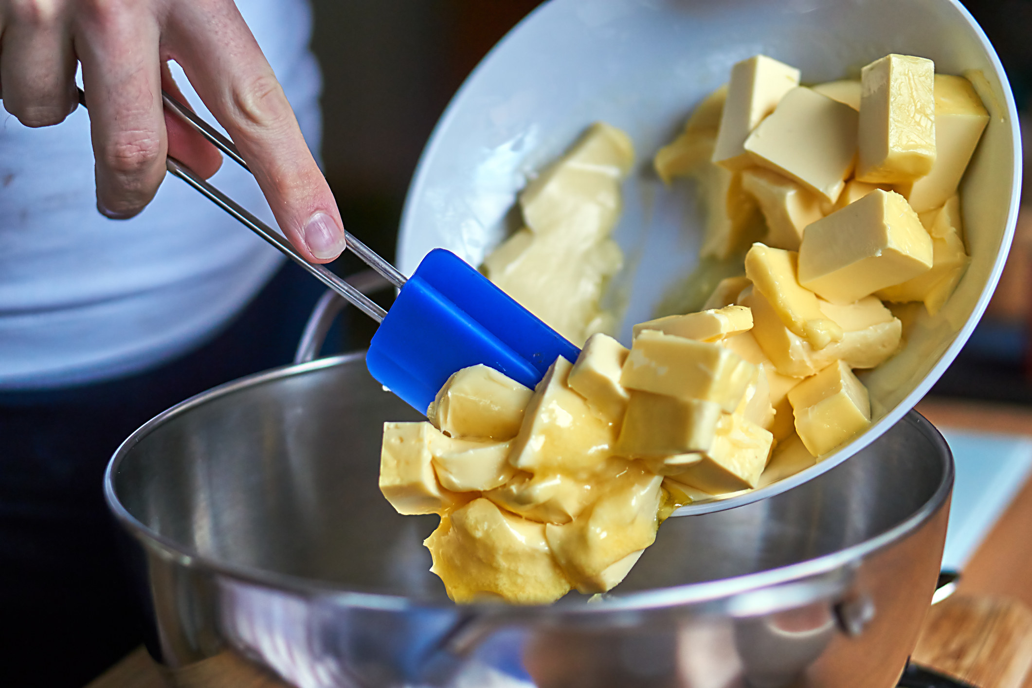 Pouring butter into a mixing bowl.
