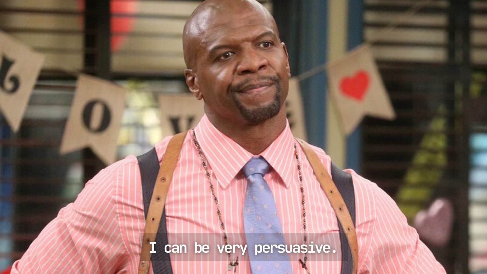 A annoyed Terry Crews, wearing a pale pink shirt and brown suspenders, standing by a decorative hanging that reads &quot;LOVE&quot;, playing his character as Sergeant Jeffords for Brooklyn Nine-Nine