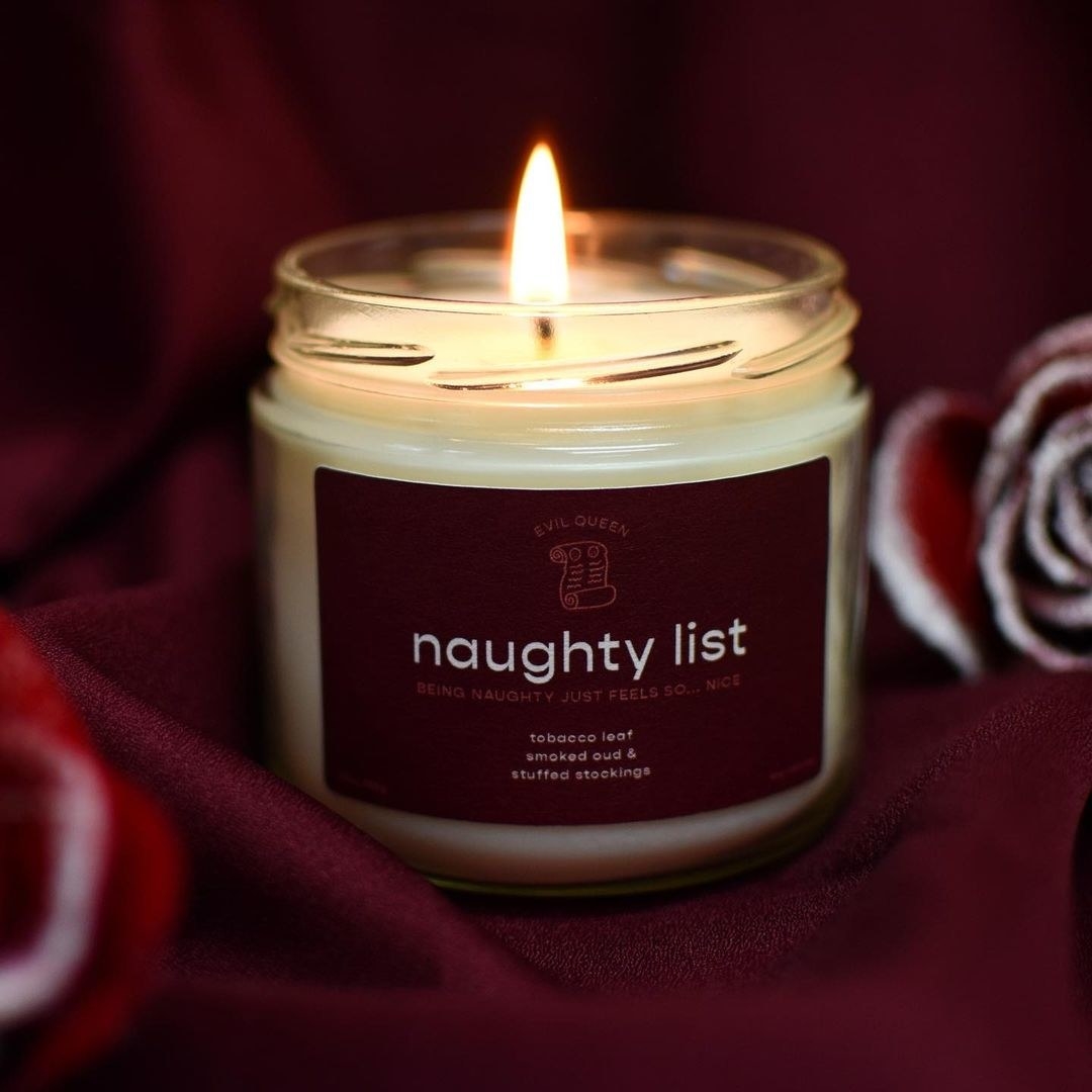 a candle with a burgundy label that says &quot;naughty list&quot;