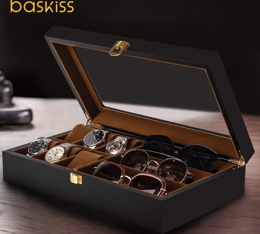 an open accessory box filled with watches and sunglasses