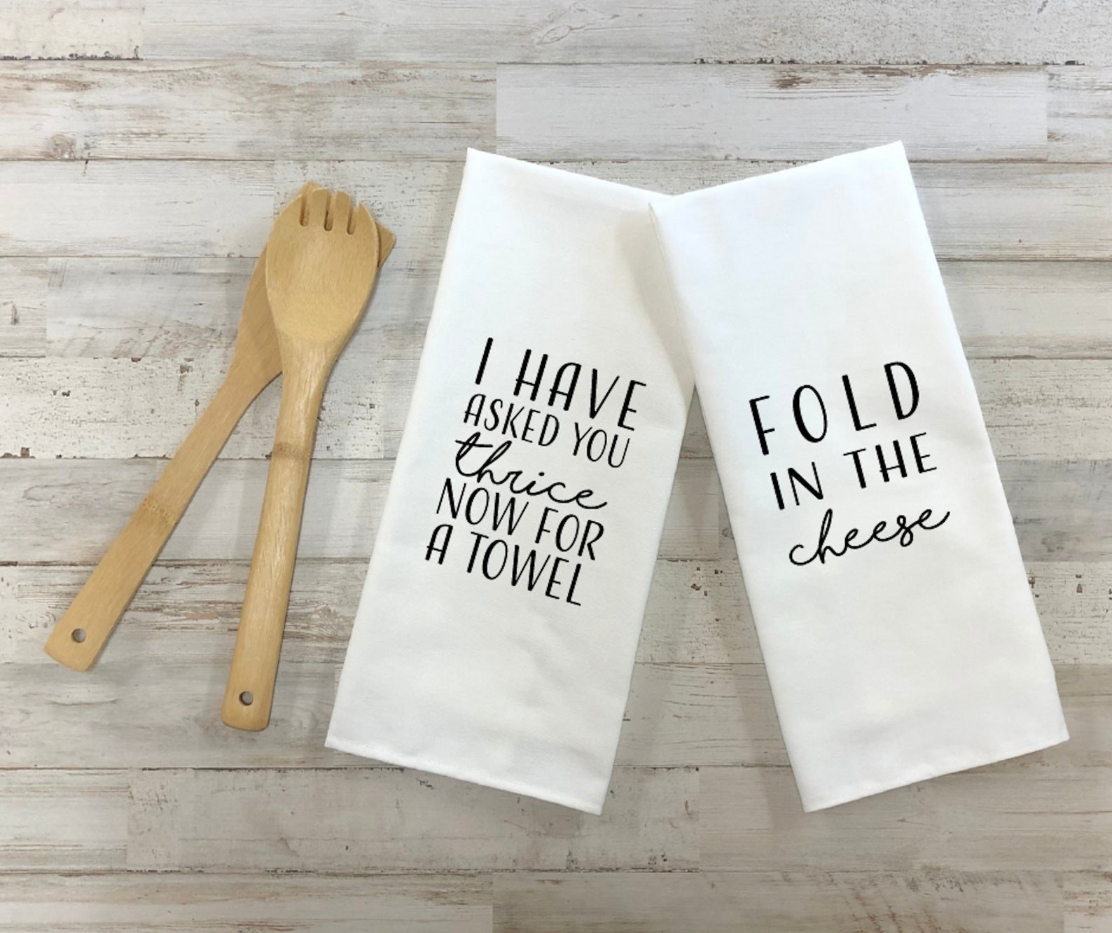 a white dish towel that says &quot;i have asked your thrice now for a towel&quot; and another that says &quot;fold in the cheese: