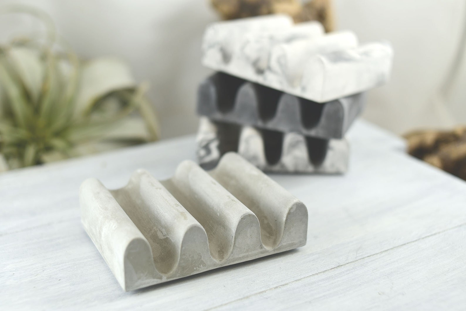 Four of the wavy soap dishes in neutral colors