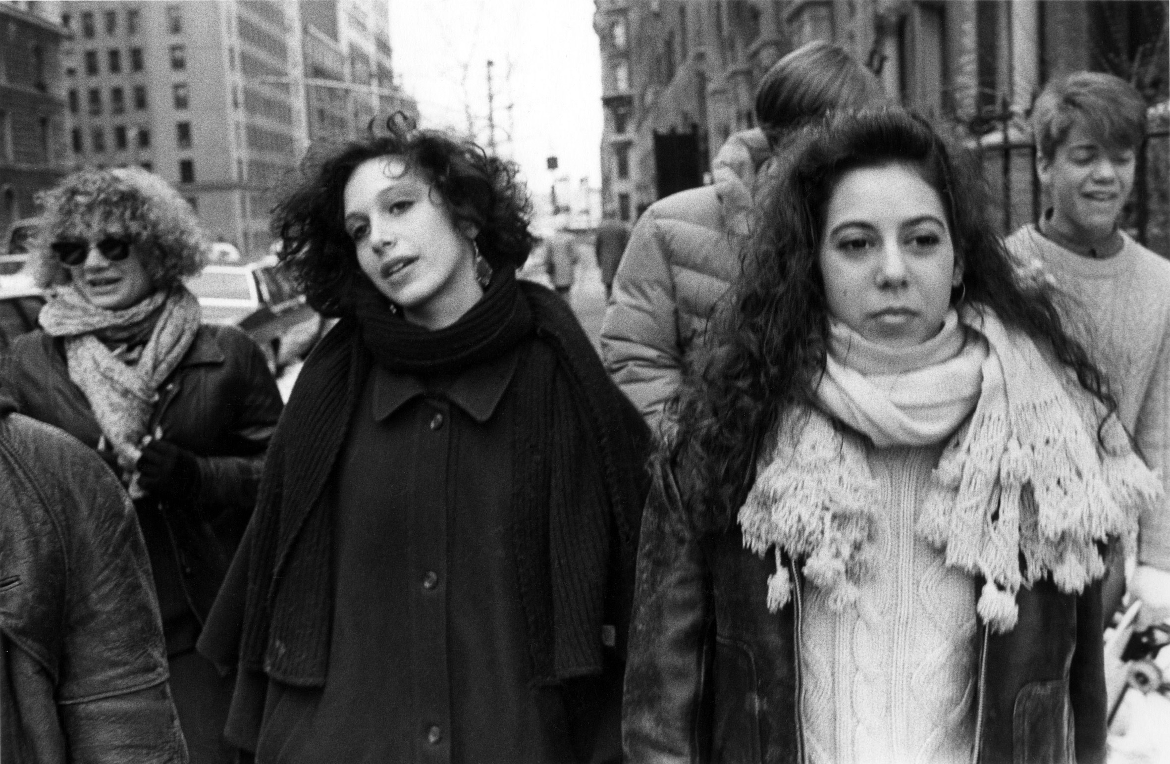 Five friends int he book walk down the street in new york, all wearing coats and scarves