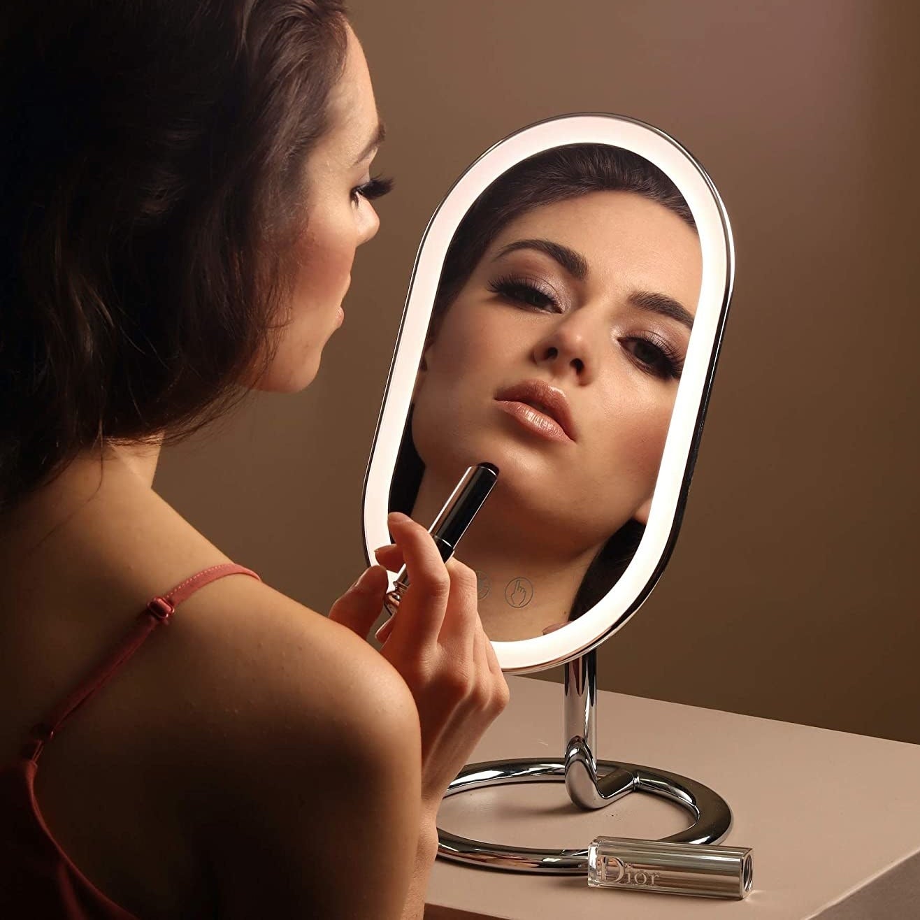 someone applying makeup in the vanity mirror