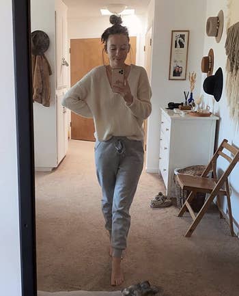 A reviewer taking a mirror selfie in the gray sweatpants