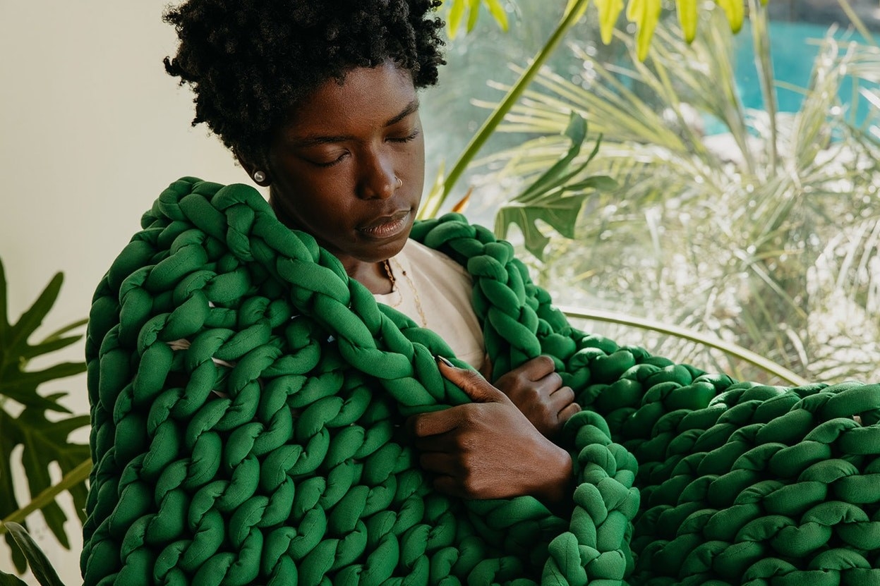 a model with a green woven blanket around them