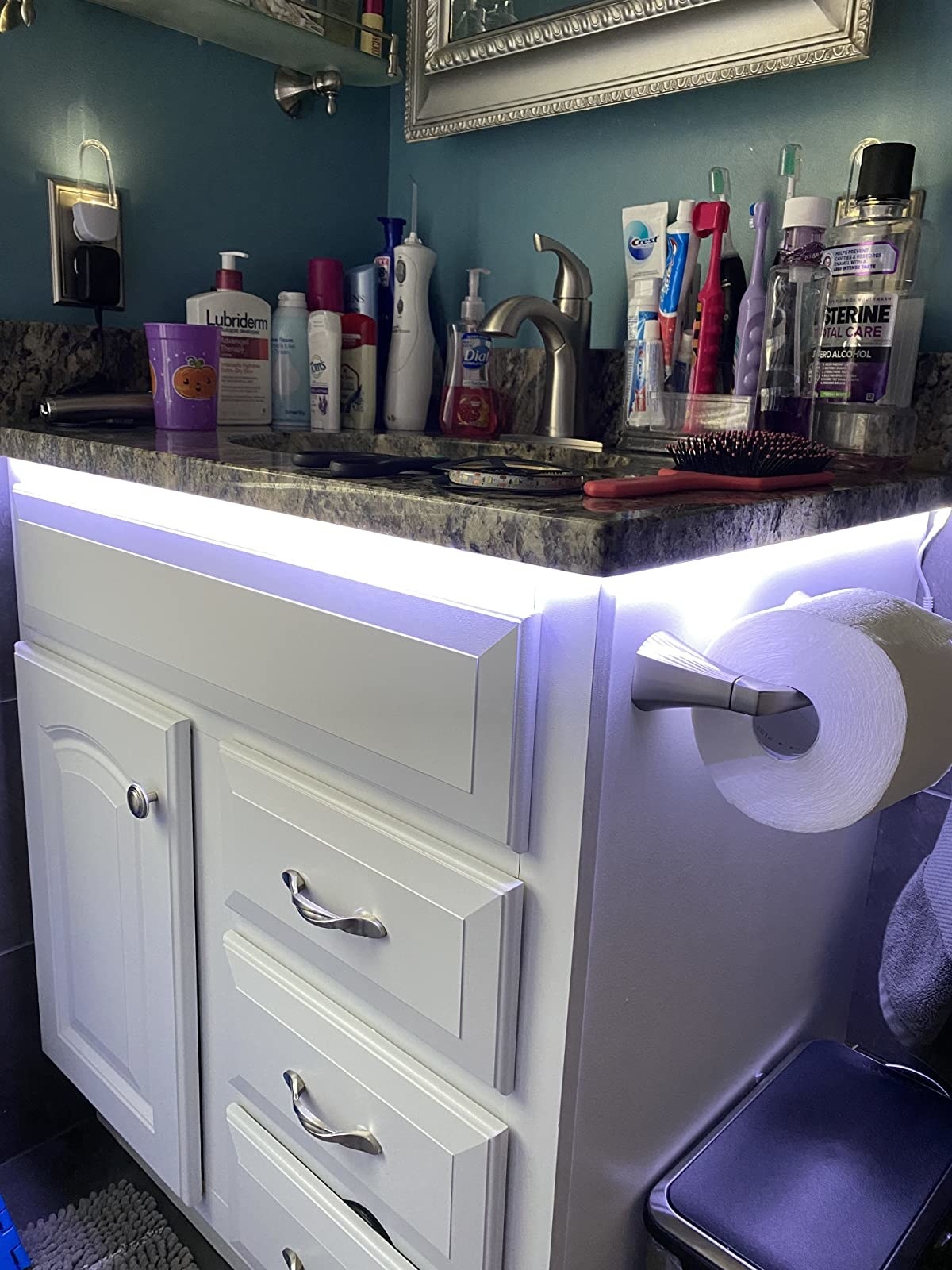 Reviewer photo of someone&#x27;s bathroom with lights installed under the counter top of their bathroom vanity