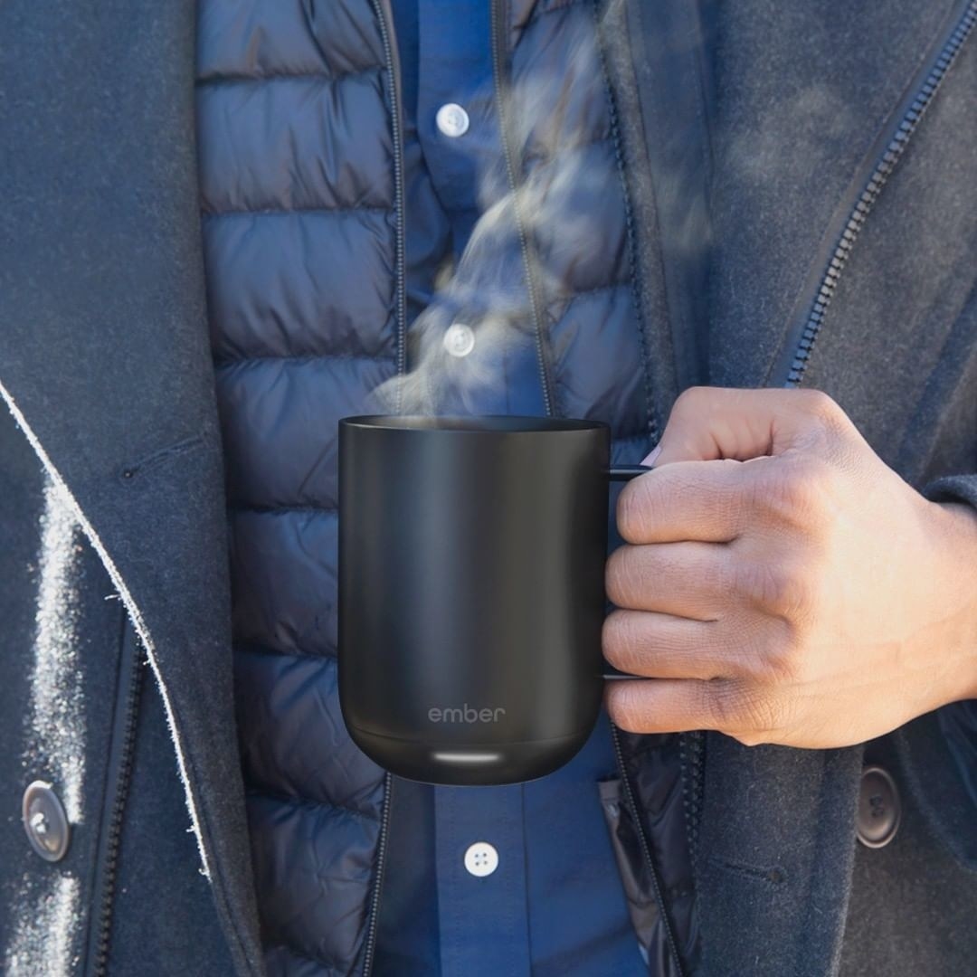 A person holding the mug with steam coming out of it
