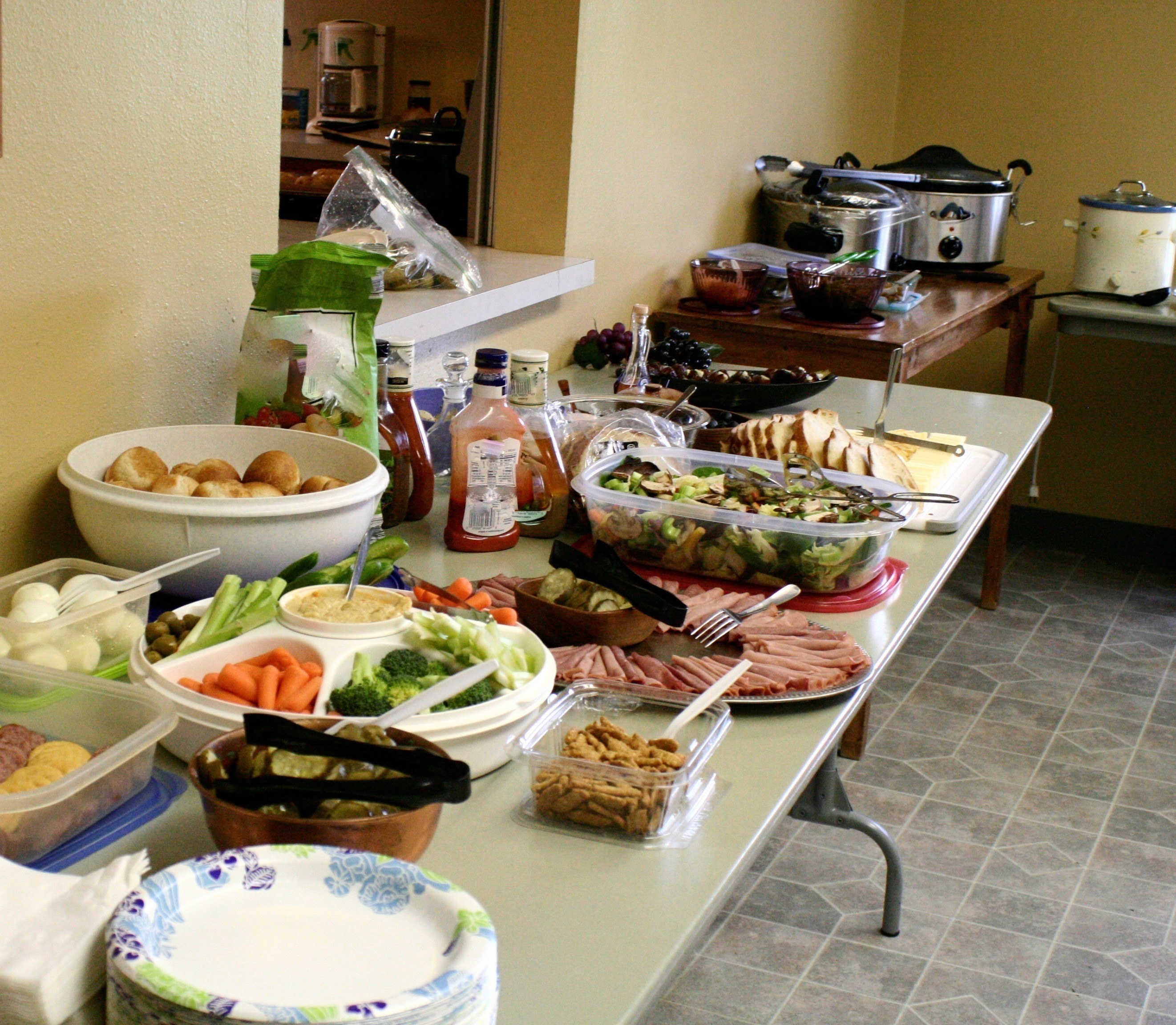 Potluck of a variety of different foods on a portable table.