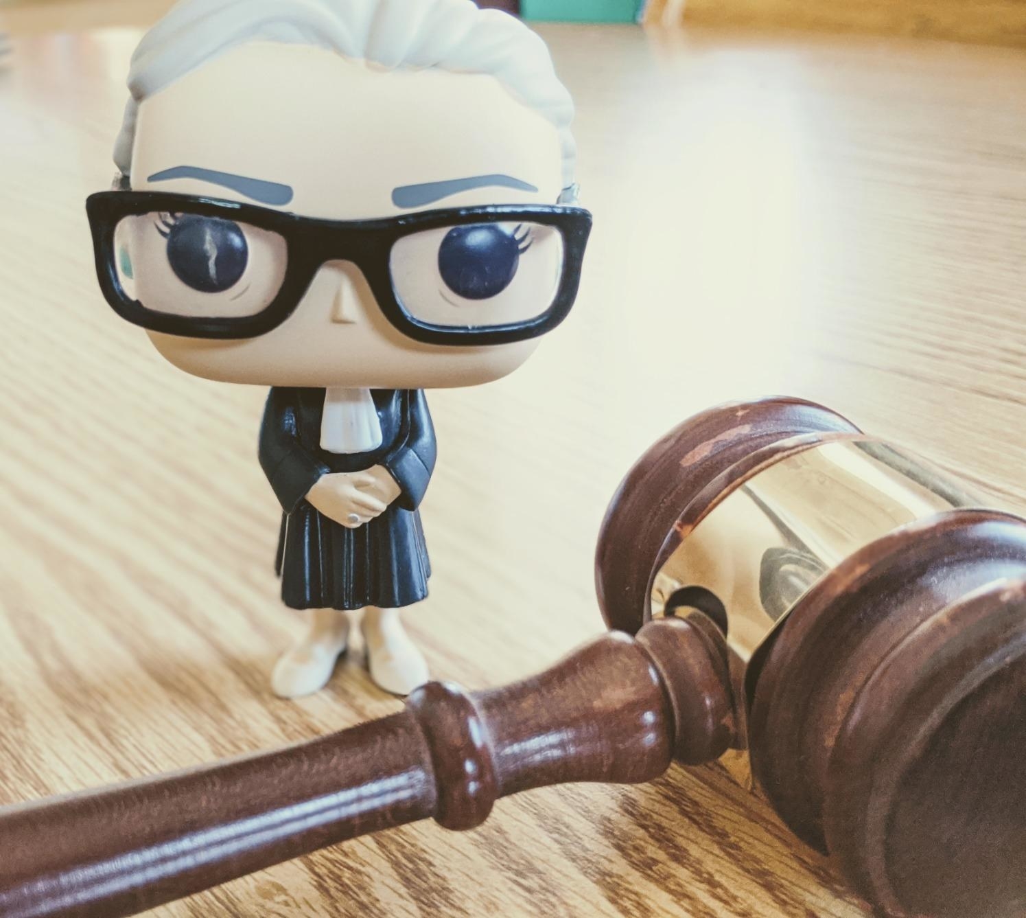 the funko pop figure next to a gavel