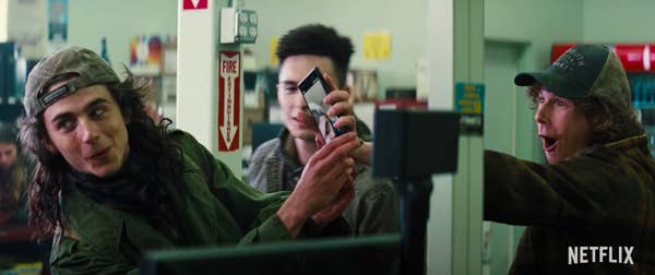 Timothée showing off a picture on his camera in a scene from the film