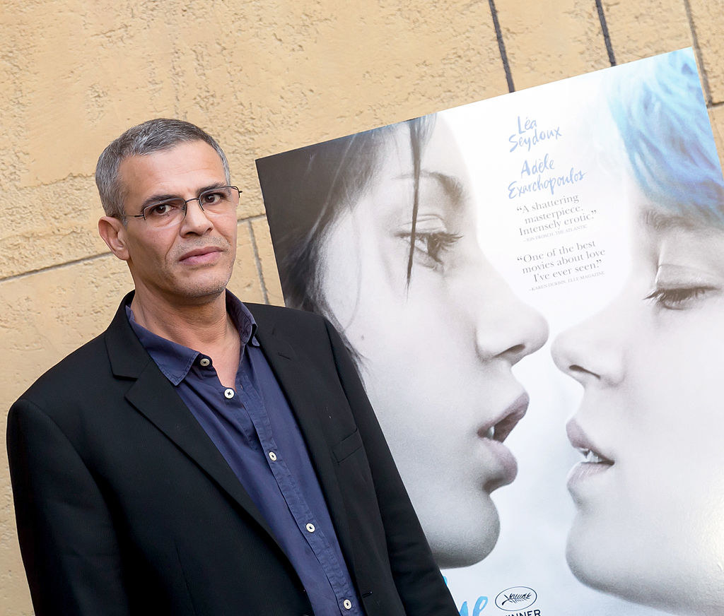 The director in front of the poster for the movie