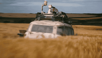 GIF of the Ecto-1 racing through a field of tall grass in the middle of nowhere