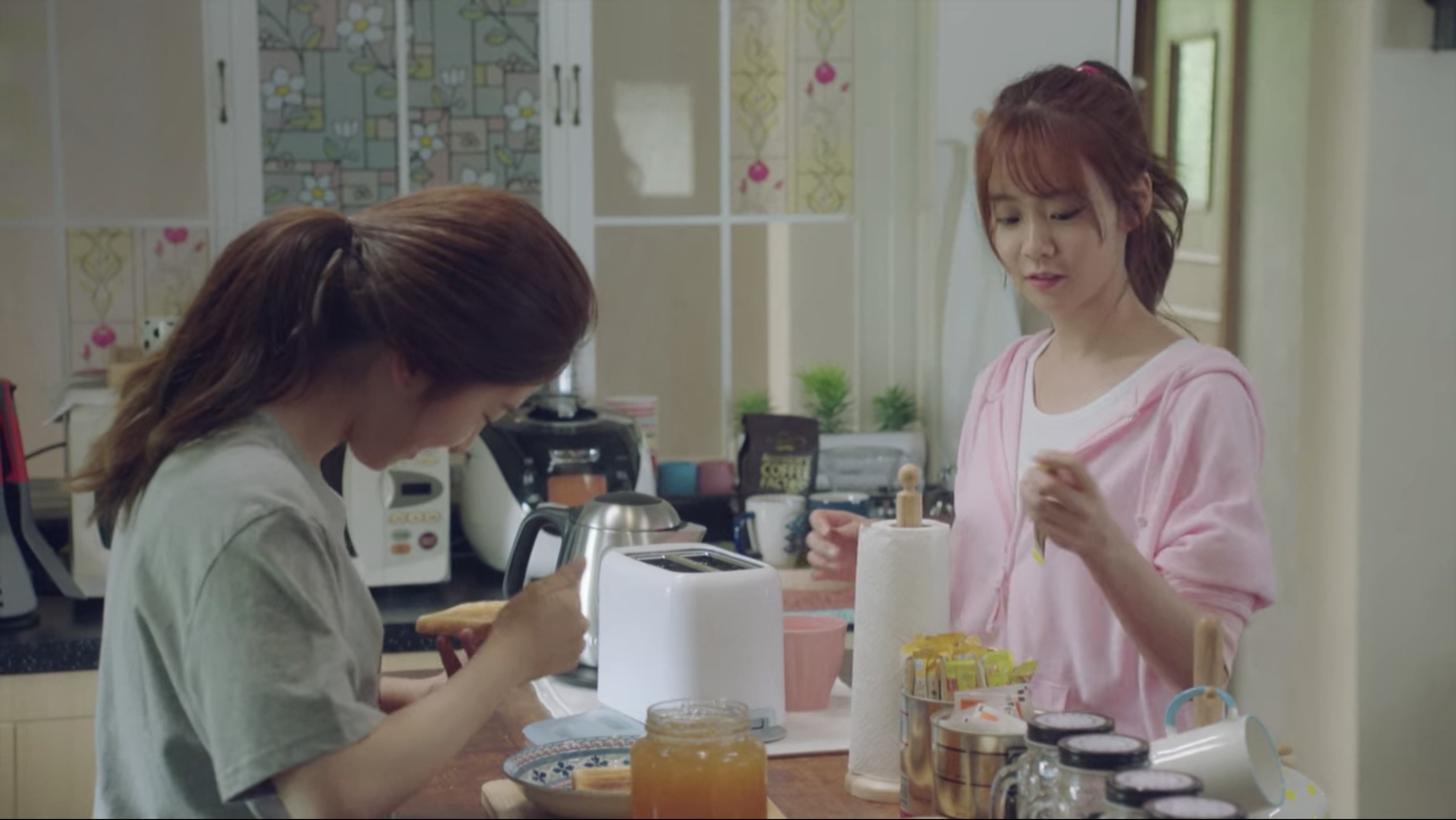 Two Korean women stand in a kitchen making breakfast.