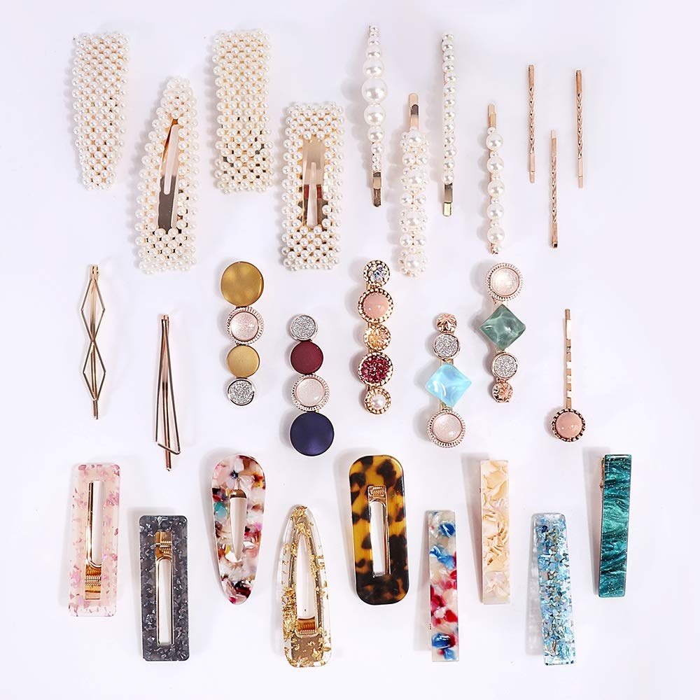 a photo of some included hair pins laid out, with eight pearl clips at the top, and eight tortoise-print clips in various colors at the bottom.