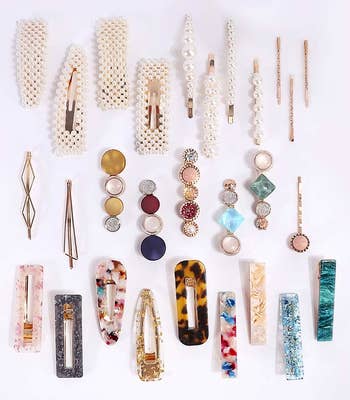 a photo of some included hair pins laid out, with eight pearl clips at the top, and eight tortoise-print clips in various colors at the bottom.