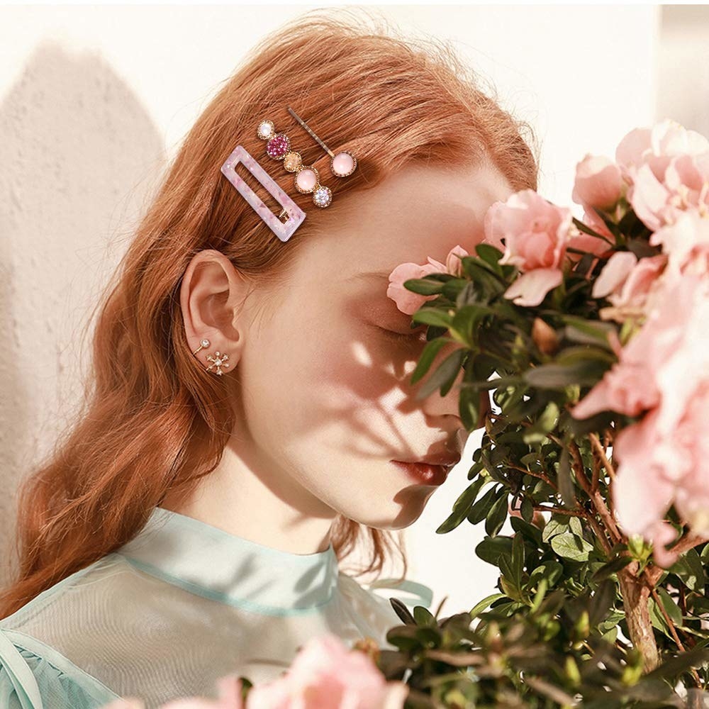 a model wears three of the pink hair clips in their hair
