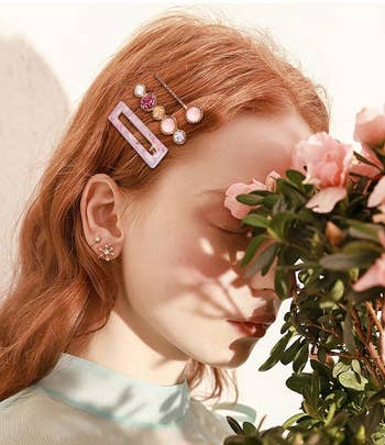 a model wears three of the pink hair clips in their hair