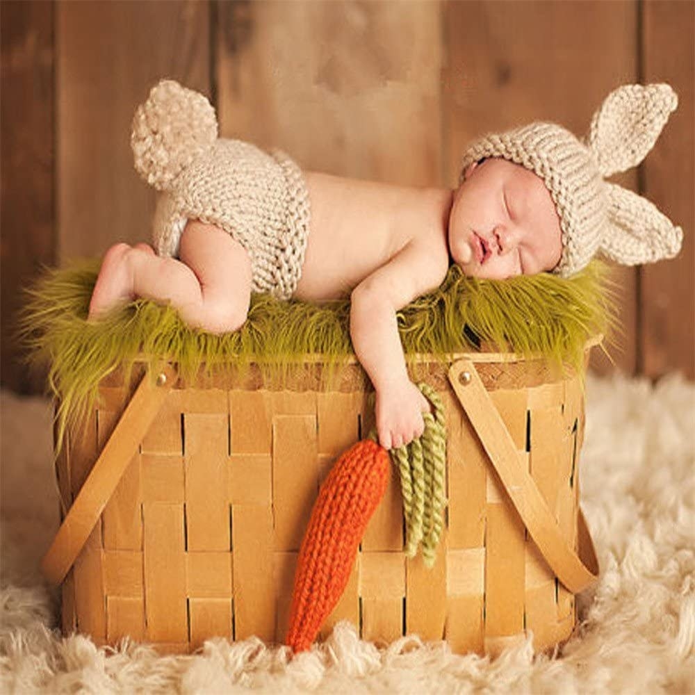 staged baby photo in a basket holding the carrot and wearing the fluffy tail bottoms and the long ear hat